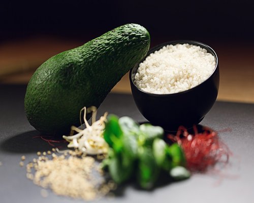 A variety of whole grains, brown rice, beans, and fresh avocado arranged beautifully on a warm kitchen table context
